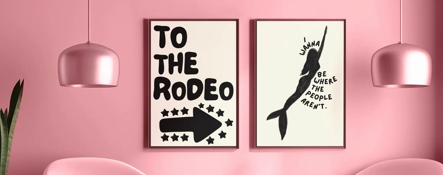 Two framed posters on a pink wall with decorative elements.